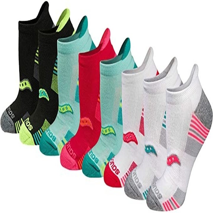 Assorted black, blue, white, and red athletic socks with Saucony logo near toes 