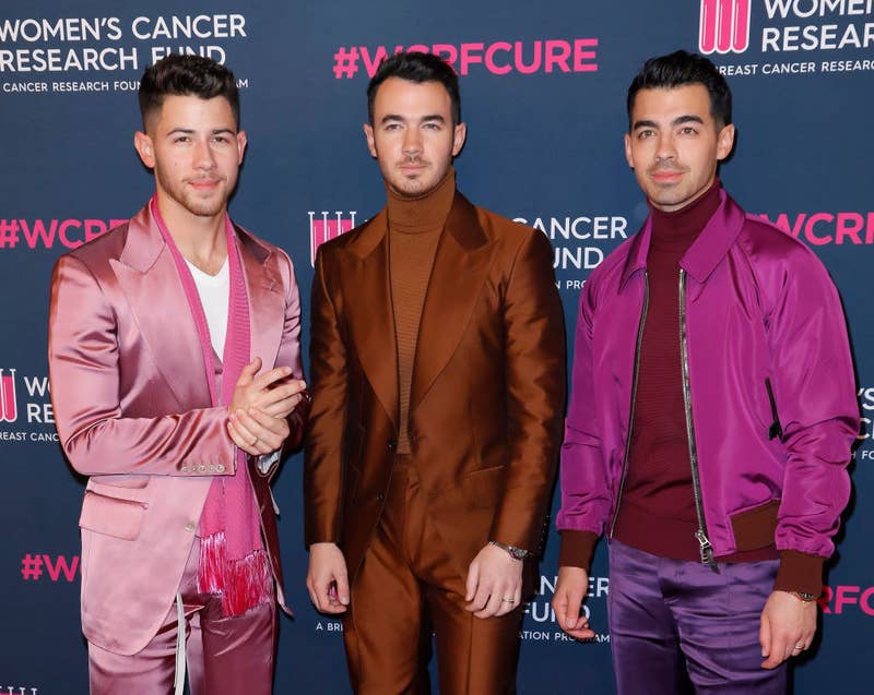 The Jonas Brothers posing on a red carpet at The Women&#x27;s Cancer Research Fund&#x27;s Unforgettable Evening in 2020