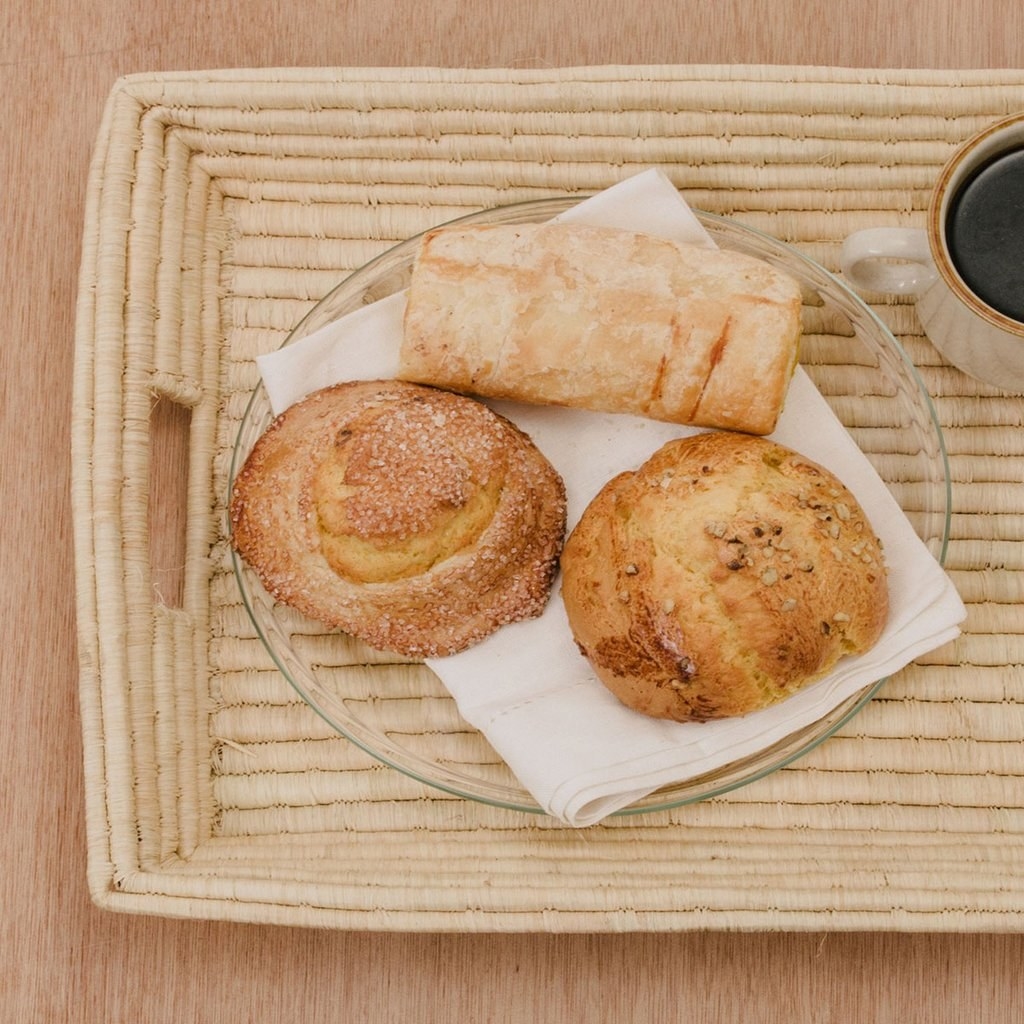 raffia tray with a plate of pastries resting on it 
