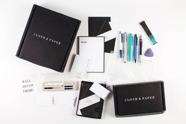an unpacked Cloth &amp;amp; Paper box featuring pens, memo pad, and other staionary items 