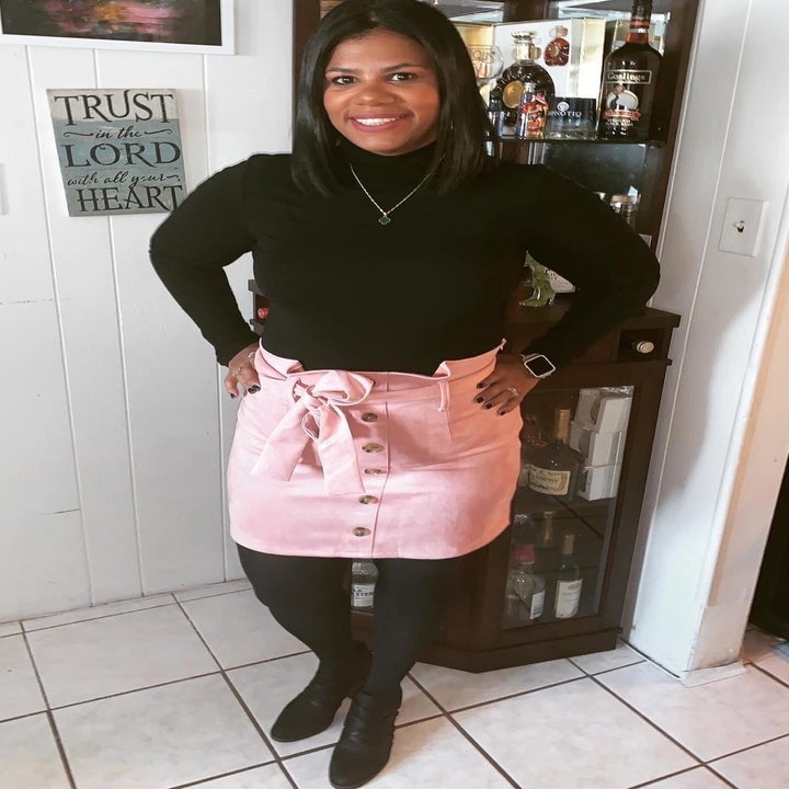 A reviewer wearing the tie belt skirt in light pink