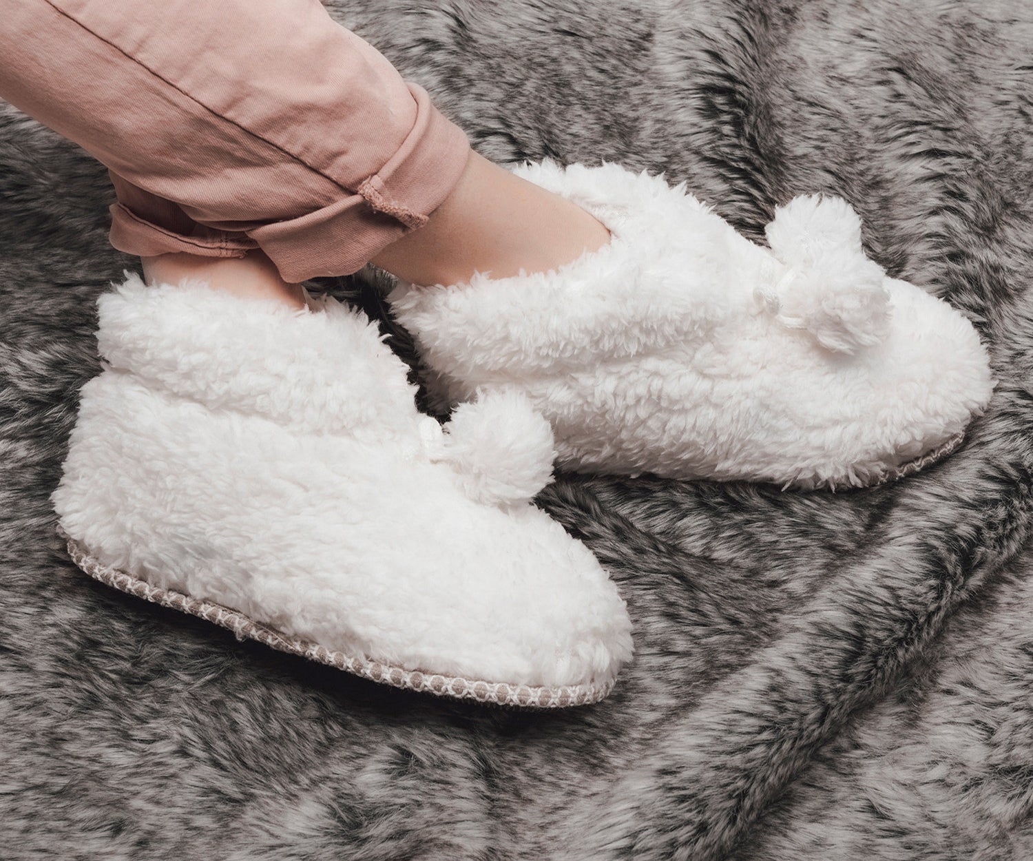 The fuzzy slipper booties with pom poms