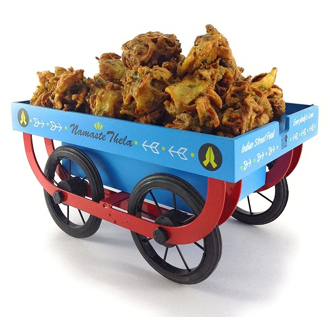 A blue and red thela-shaped snack platter serving pakoras.