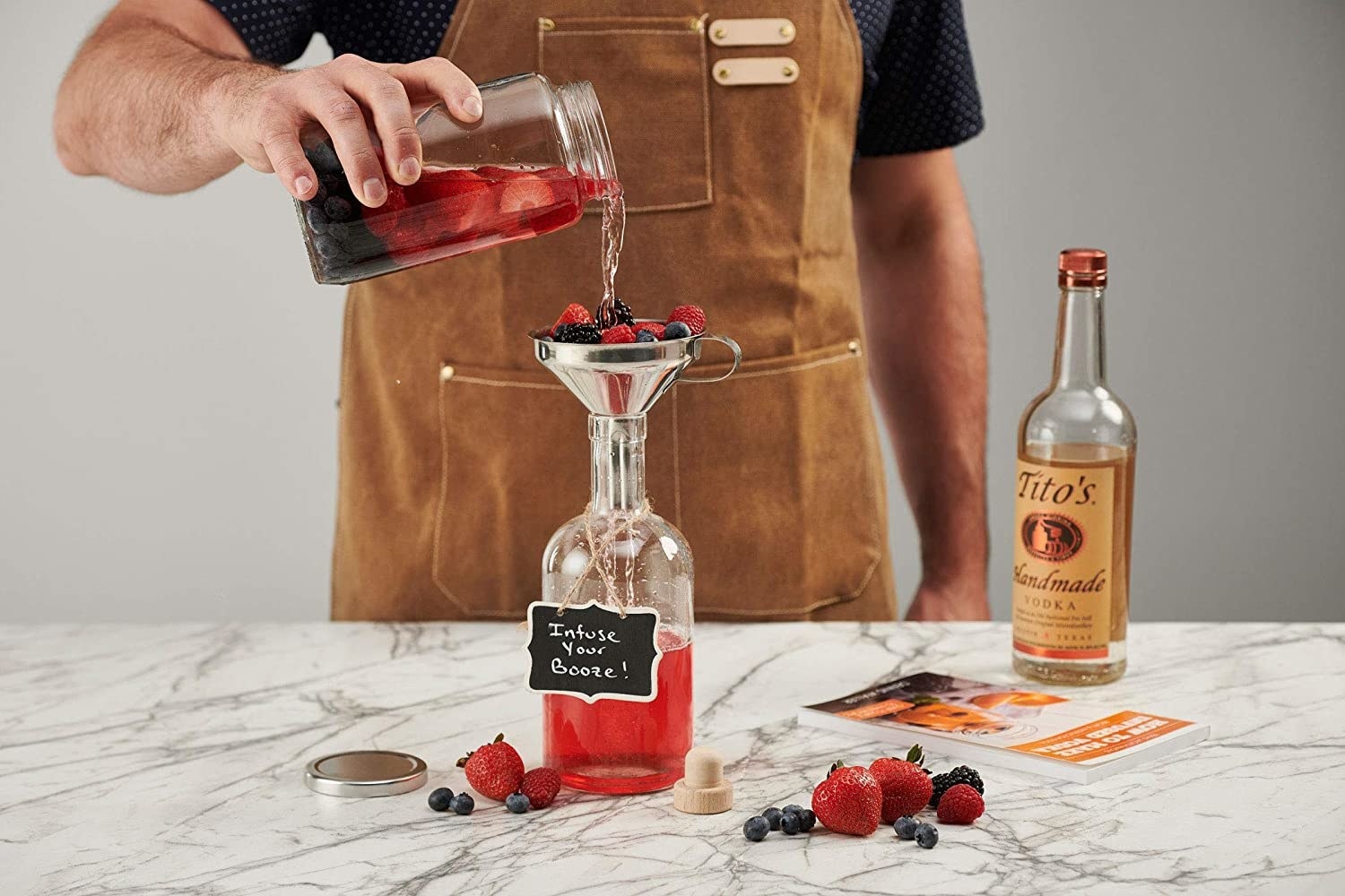 person pouring a berry concoction into a funnel with berries 