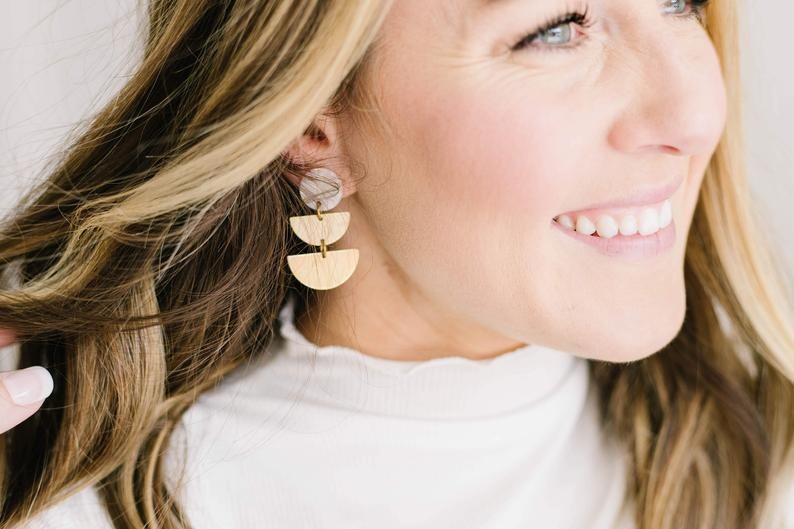 Model wearing double half-moon earring on right ear