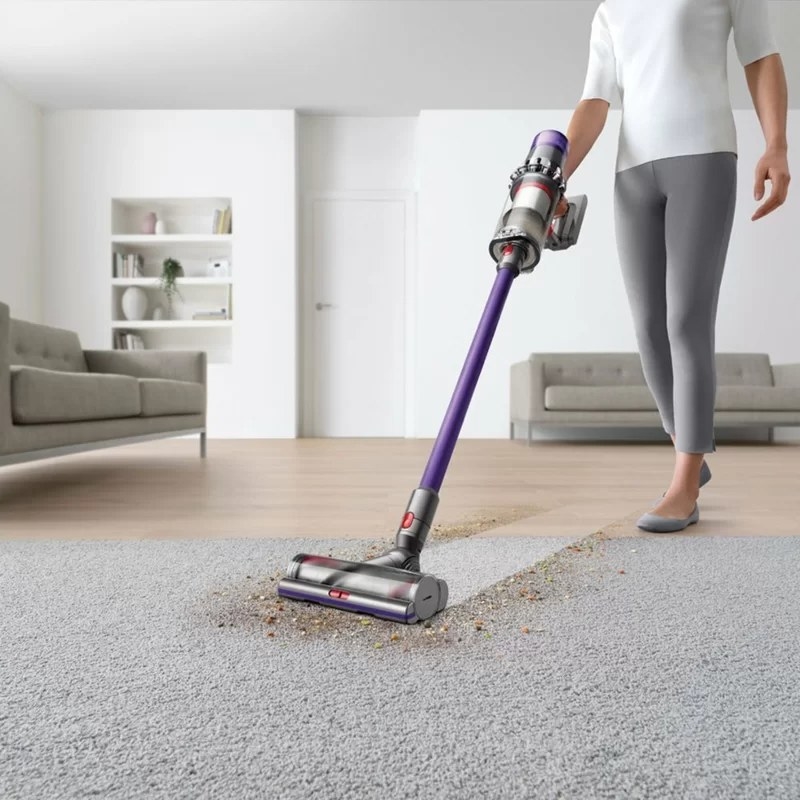 A model using the stick vacuum to clean hardwood and carpeted floors