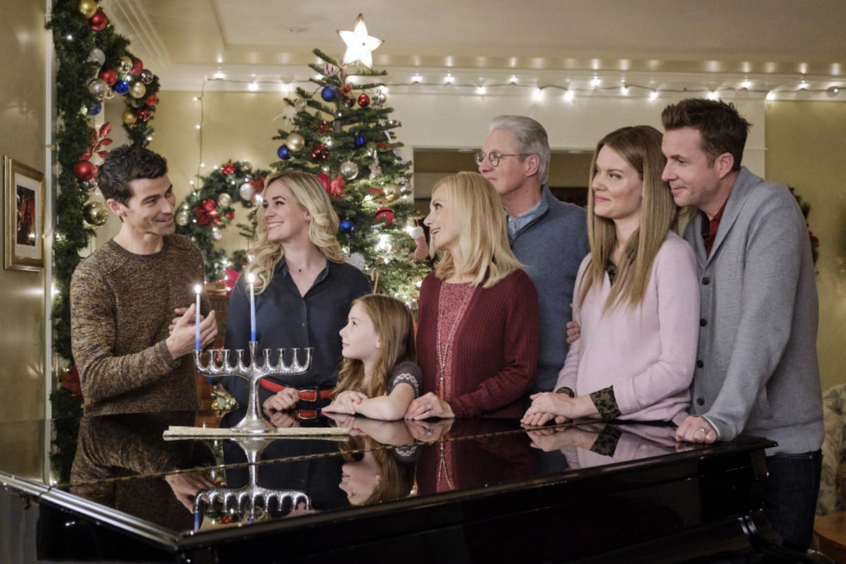 Joel lighting the menorah at Brooke&#x27;s house with her family