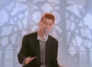 A GIF Rick Astley dancing in front of a microphone