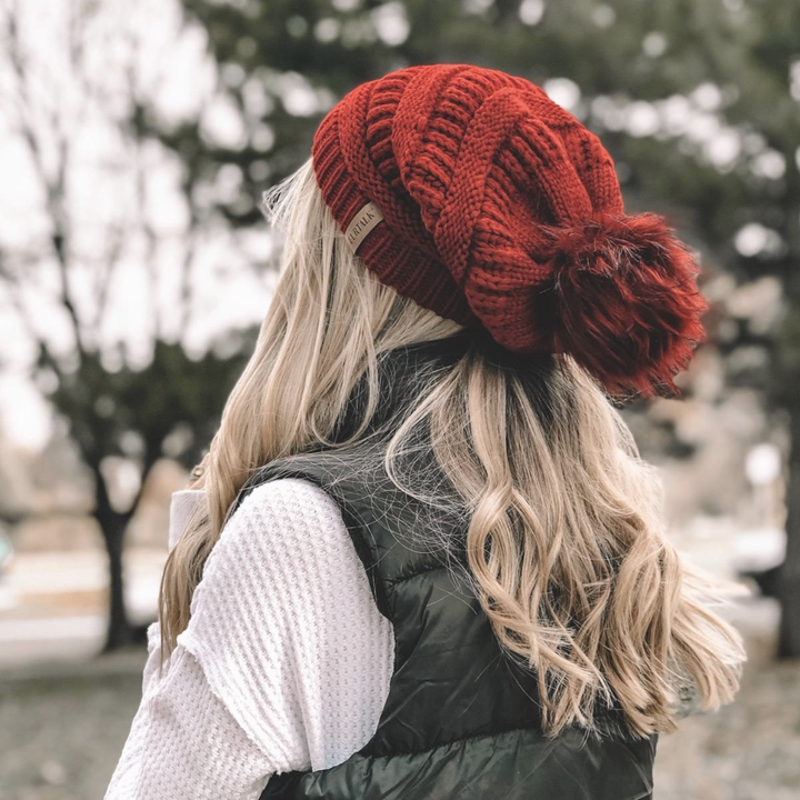 reviewer wearing the hat and the photo from the back to show the slouchiness of the hat and the pom pom