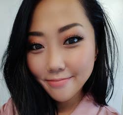 Asian reviewer wearing a light pink shade on their cheeks
