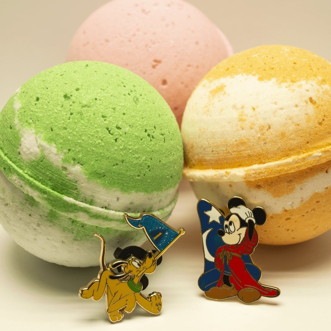 bath bombs with mickey and pluto pins in front 