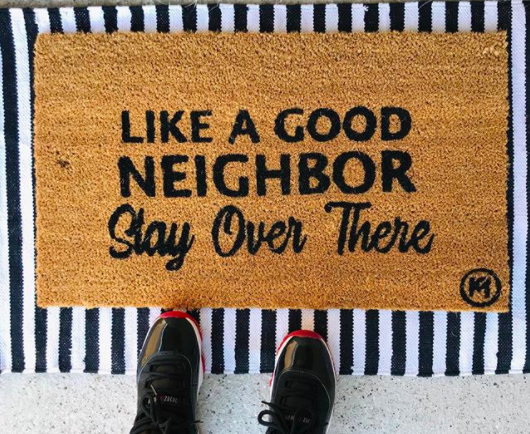 door mat that says like a good neighbor stay over there 