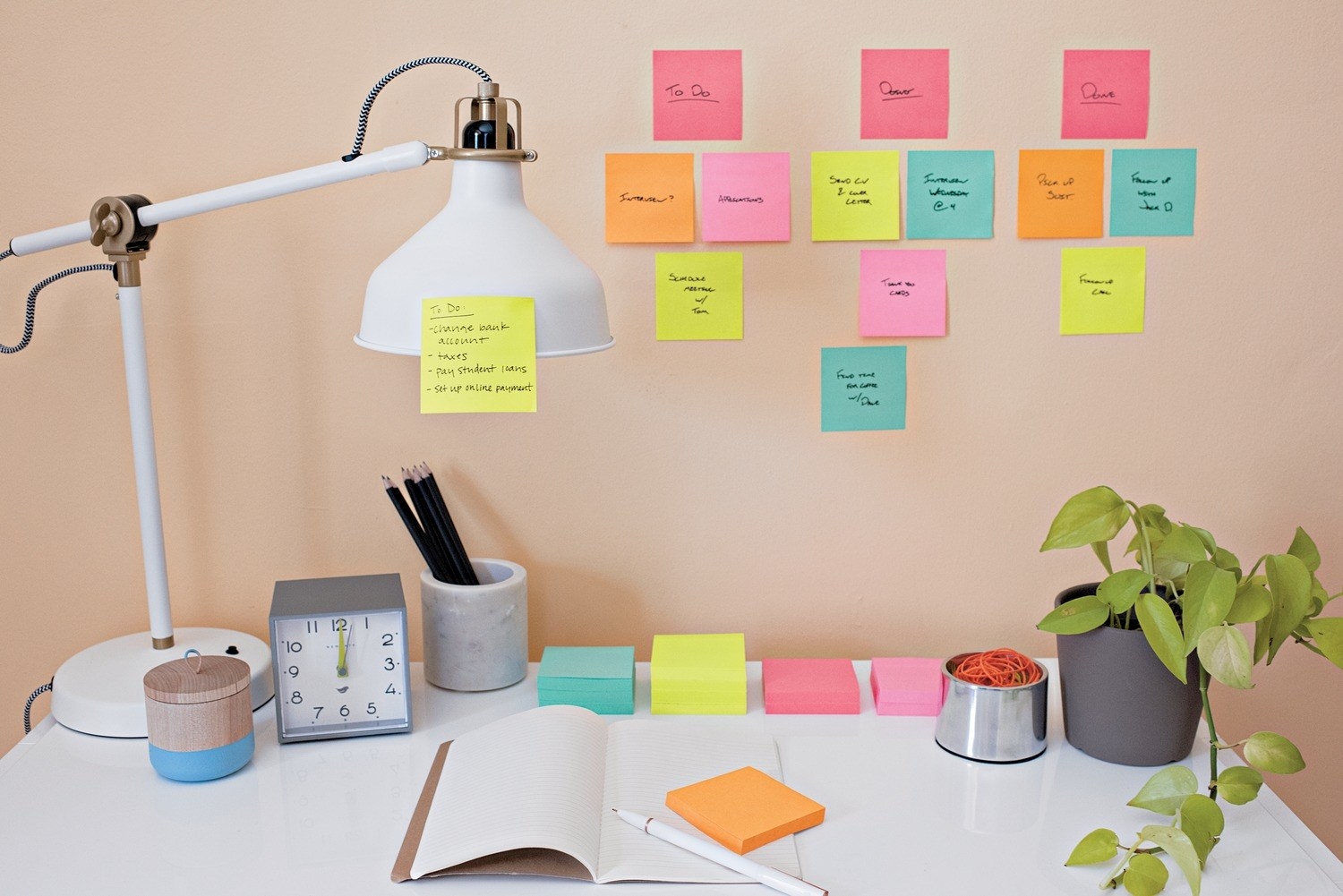 A wall with different bright-colored sticky notes on it