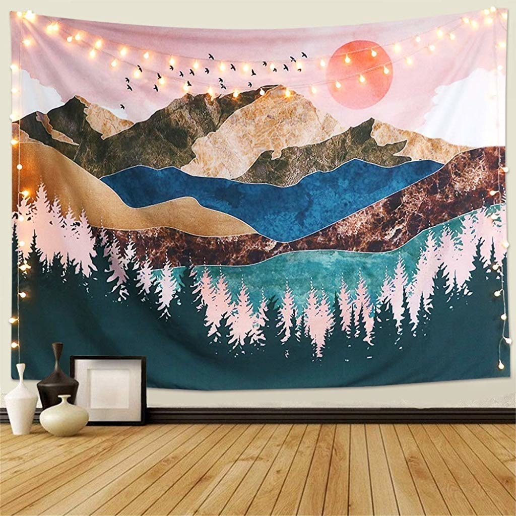 The tapestry has a forest and mountain print