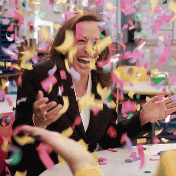 Kamala Harris laughing while confetti falls