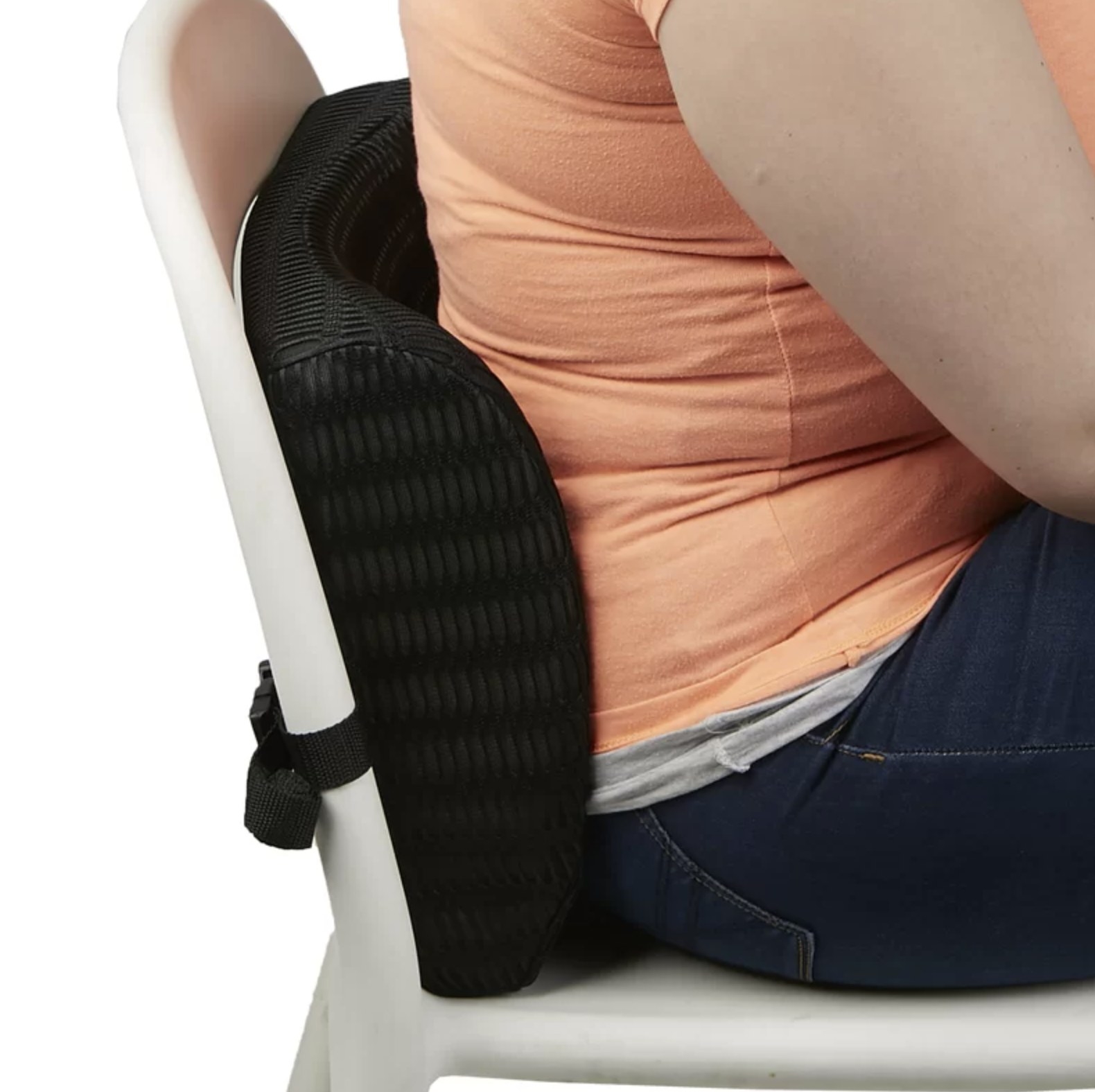 Person is sitting on a chair with a lumbar cushion attached to the back