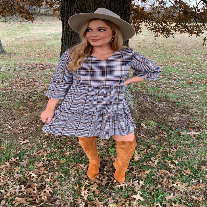 A reviewer wearing the short, three quarter sleeve dress in plaid