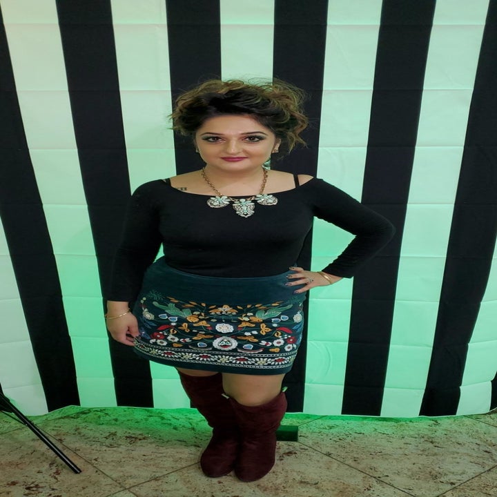 Reviewer wearing the mid-calf length skirt in green with embroidered pattern on it