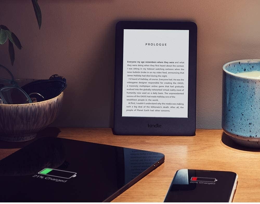 A black kindle with a white backlit screen showing the text of a book 