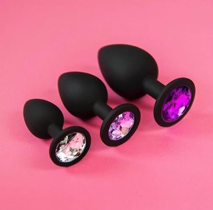 The black set of butt plugs with crystals on the end arranged in a line