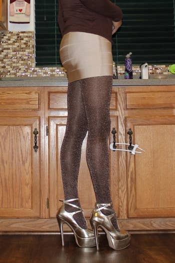 A reviewer wearing the black and copper metallic tights