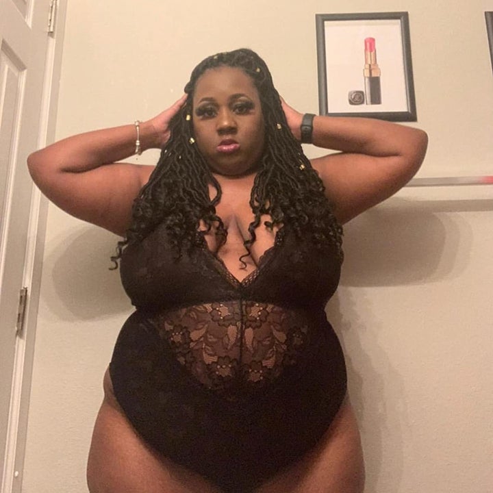 A reviewer wearing the bodysuit, which is more sheer in the middle, in black