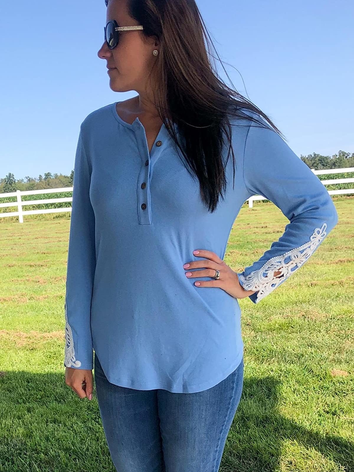 A reviewer wearing the shirt in blue with white lace details at the sleeves