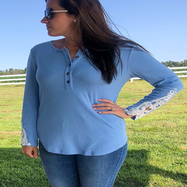 Reviewer wearing the shirt in blue with white lace details at the sleeves