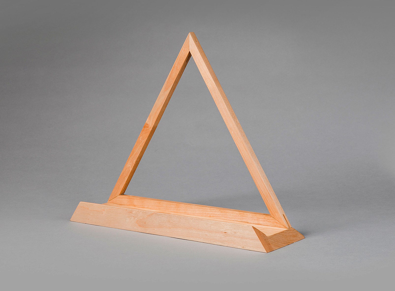 A triangle shaped wooden stand for vinyls