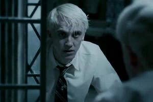 Draco Malfoy looking at himself in the mirror 