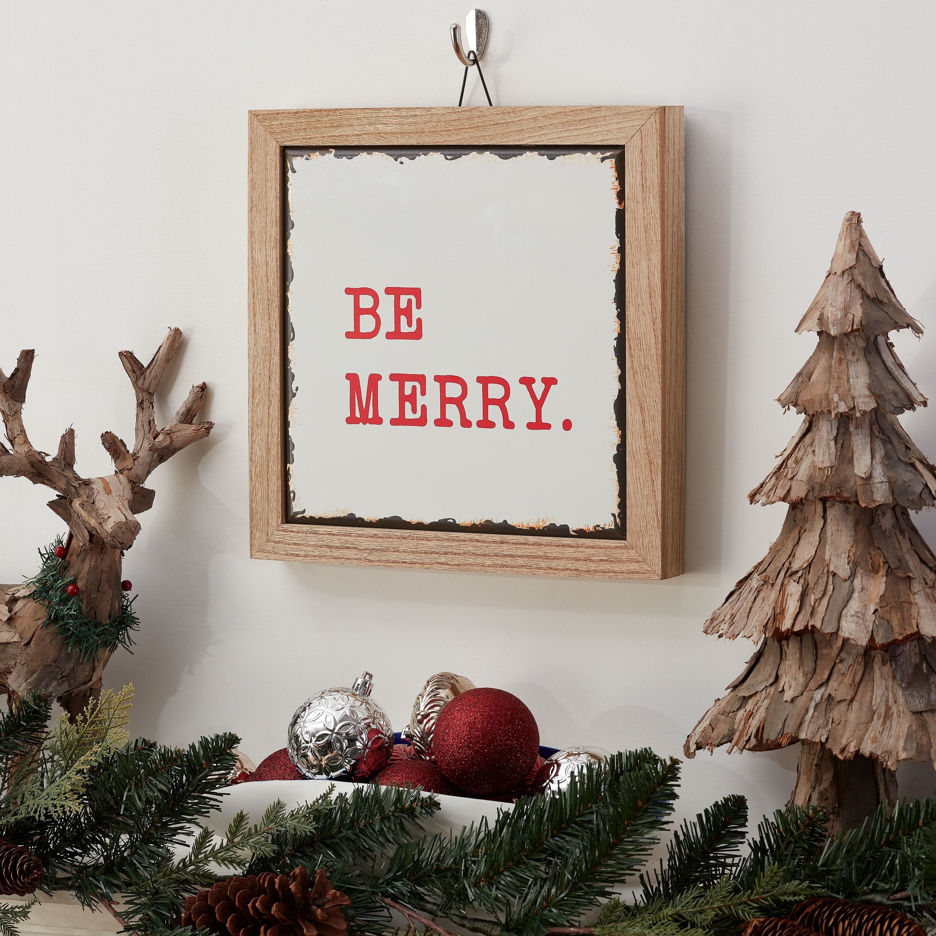 The sign hung on a wall beside several rustic holiday decorations