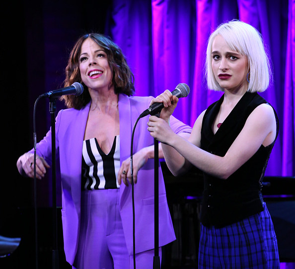 Lydia and Delia singing together, Lydia looking annoyed and Delia looking happy