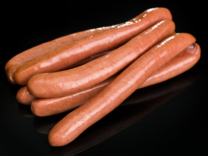 bunch of frankfurter sausages on black background