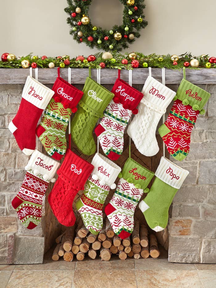 The custom stockings in an assortment of colors hanging from a fire place