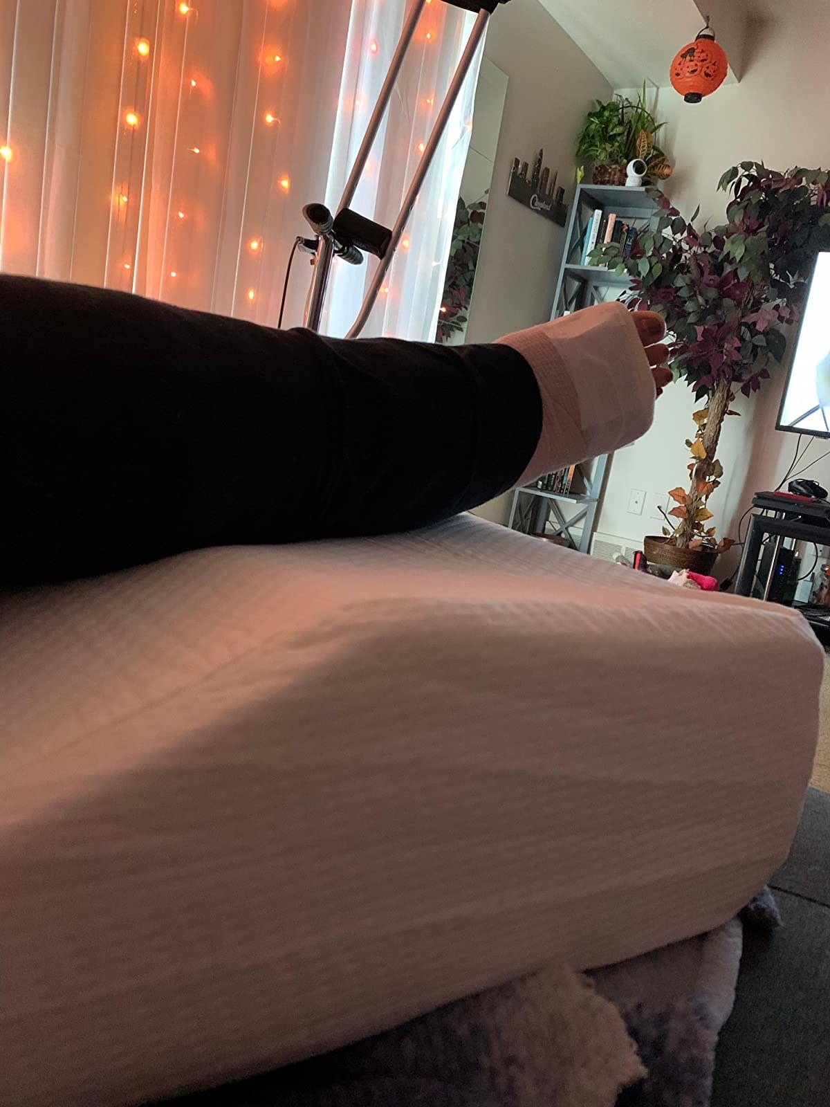 Reviewer props up feet on white leg pillow