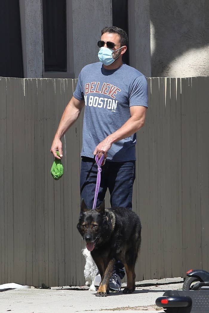 ben walking a dog while holding a poop bag