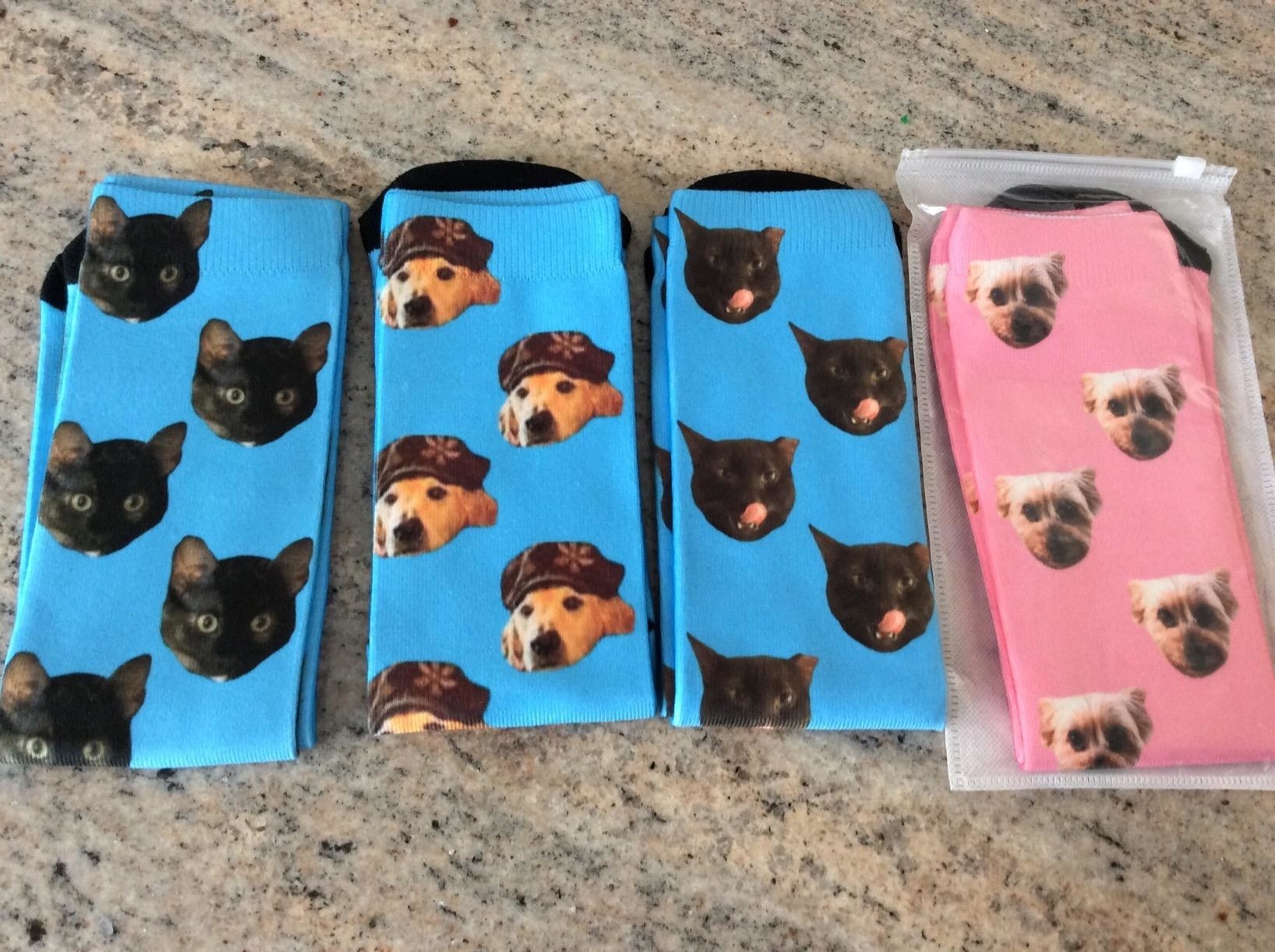 The custom socks, which have a solid background color, and the pet&#x27;s face as a repeating pattern
