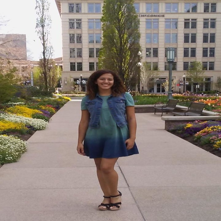 A reviewer wearing the dress under a denim vest