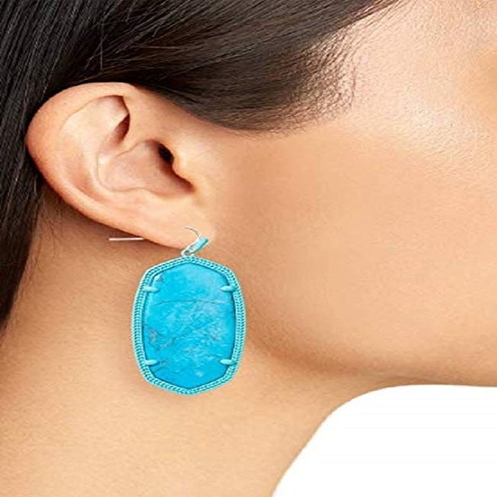Model wearing the earrings in aqua blue