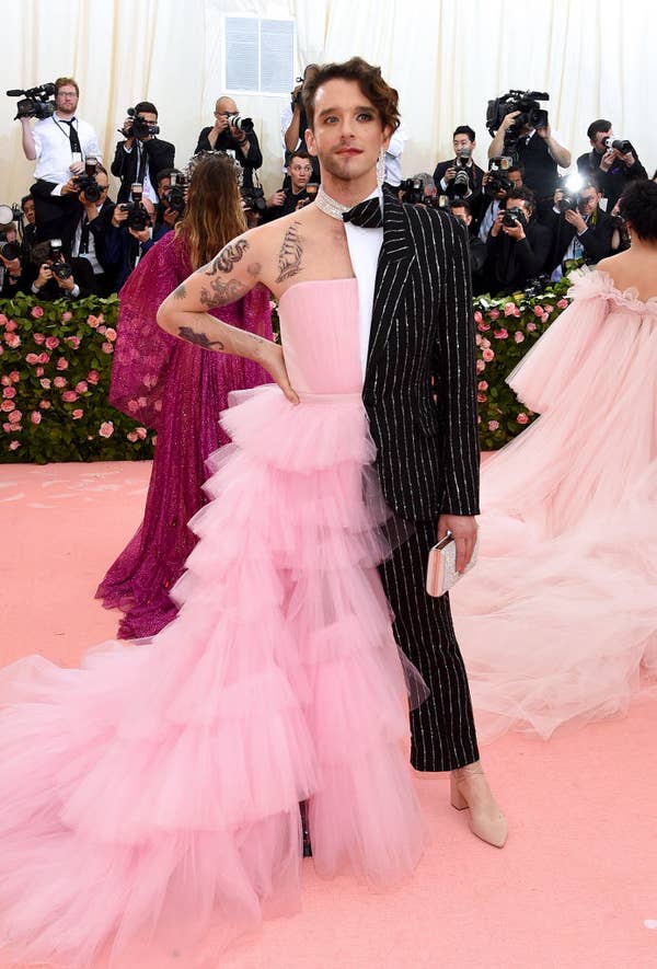 Michael in an outfit that's half a ballgown with ruffled tulle and a strapless top, and half a suit with glittered pinstripes and cropped pants with a nude heel