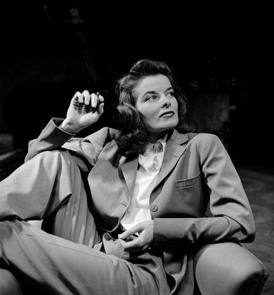 Katharine in a classic suit with buttons and a silky high neck top underneath