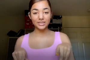 A young woman in a pink shirt using sign language