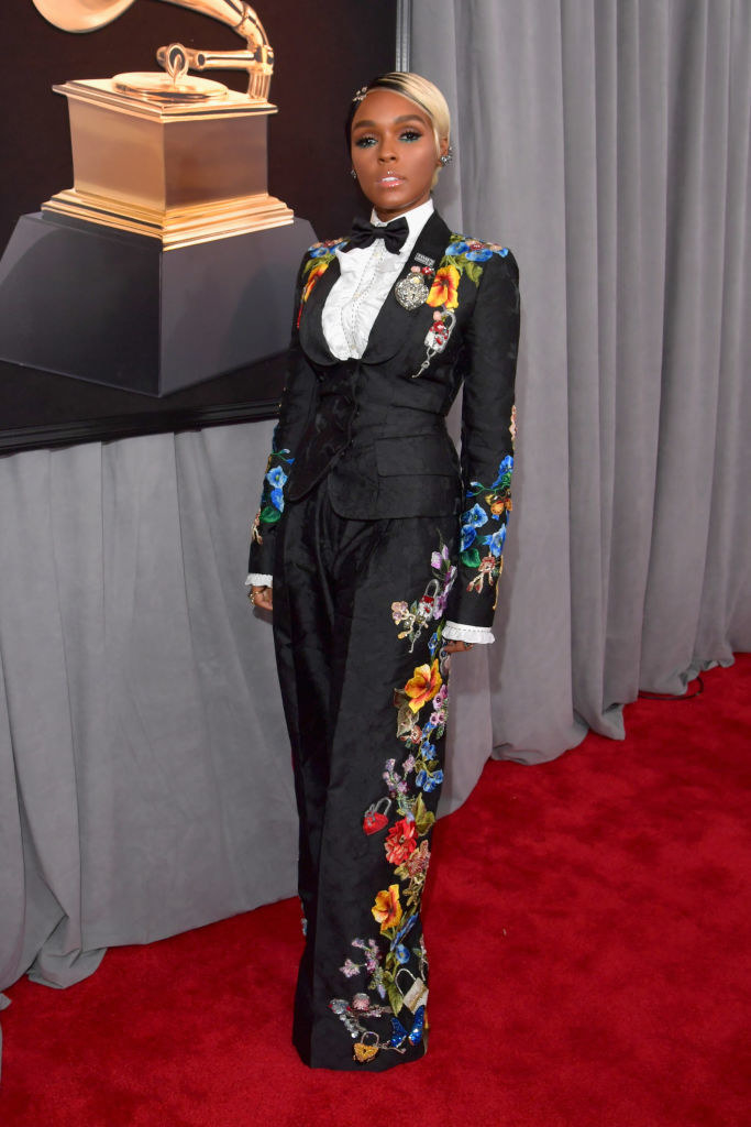 Janelle in a floral patterned tuxedo suit with loose pants and a frilled button up with bowtie