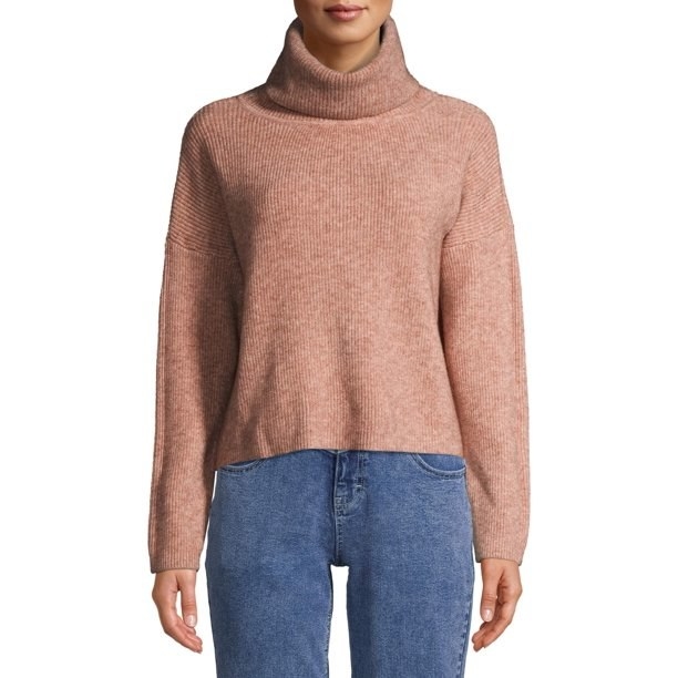 Model in cowl neck sweater and jeans