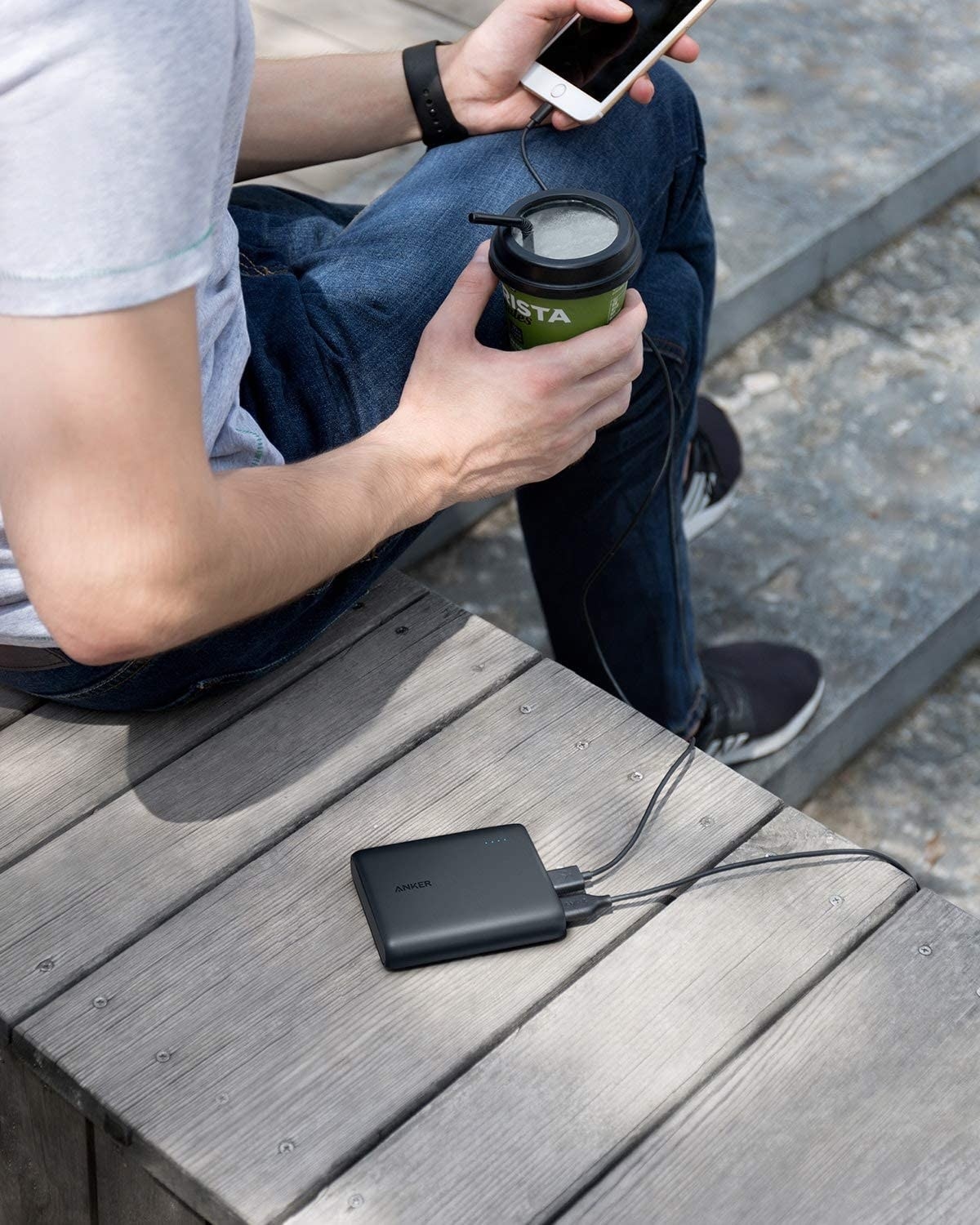 person sitting on a bench with their portable charger