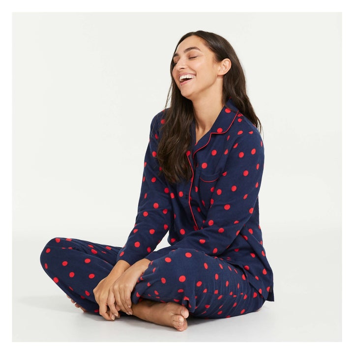 A model in navy blue pyjamas with red polka dots
