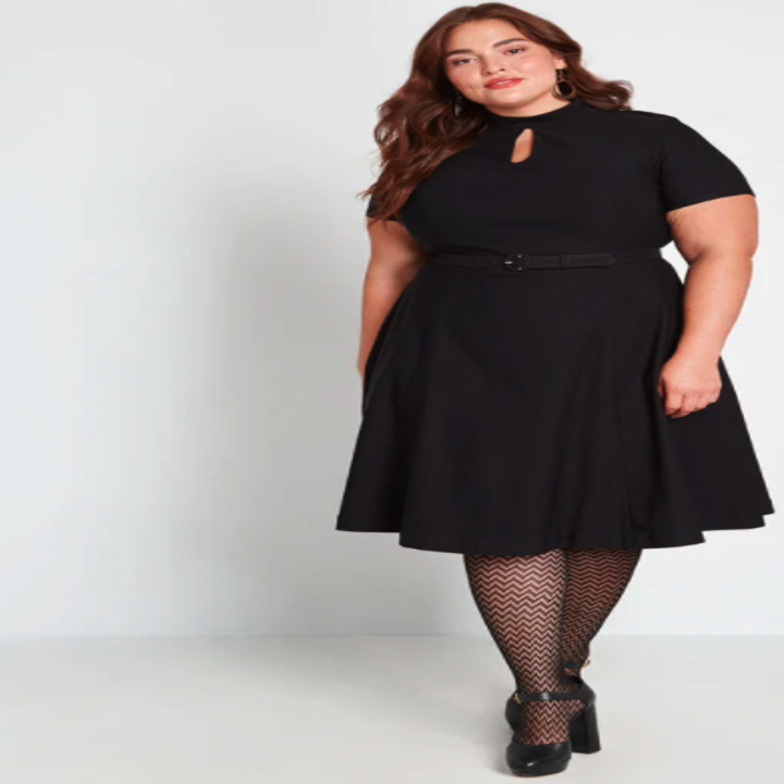 model wearing a black tea-length dress with short sleeves and a keyhole neckline