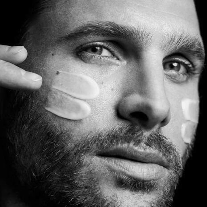 A model applying the cream to their face