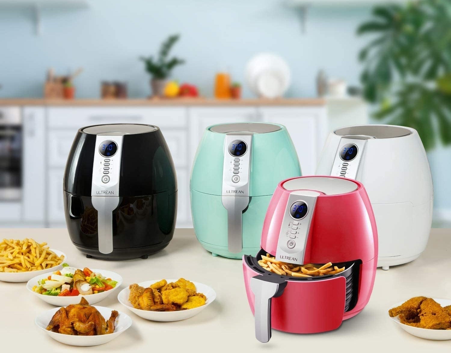 A set of four air fryers in varying colours arranged on a counter
