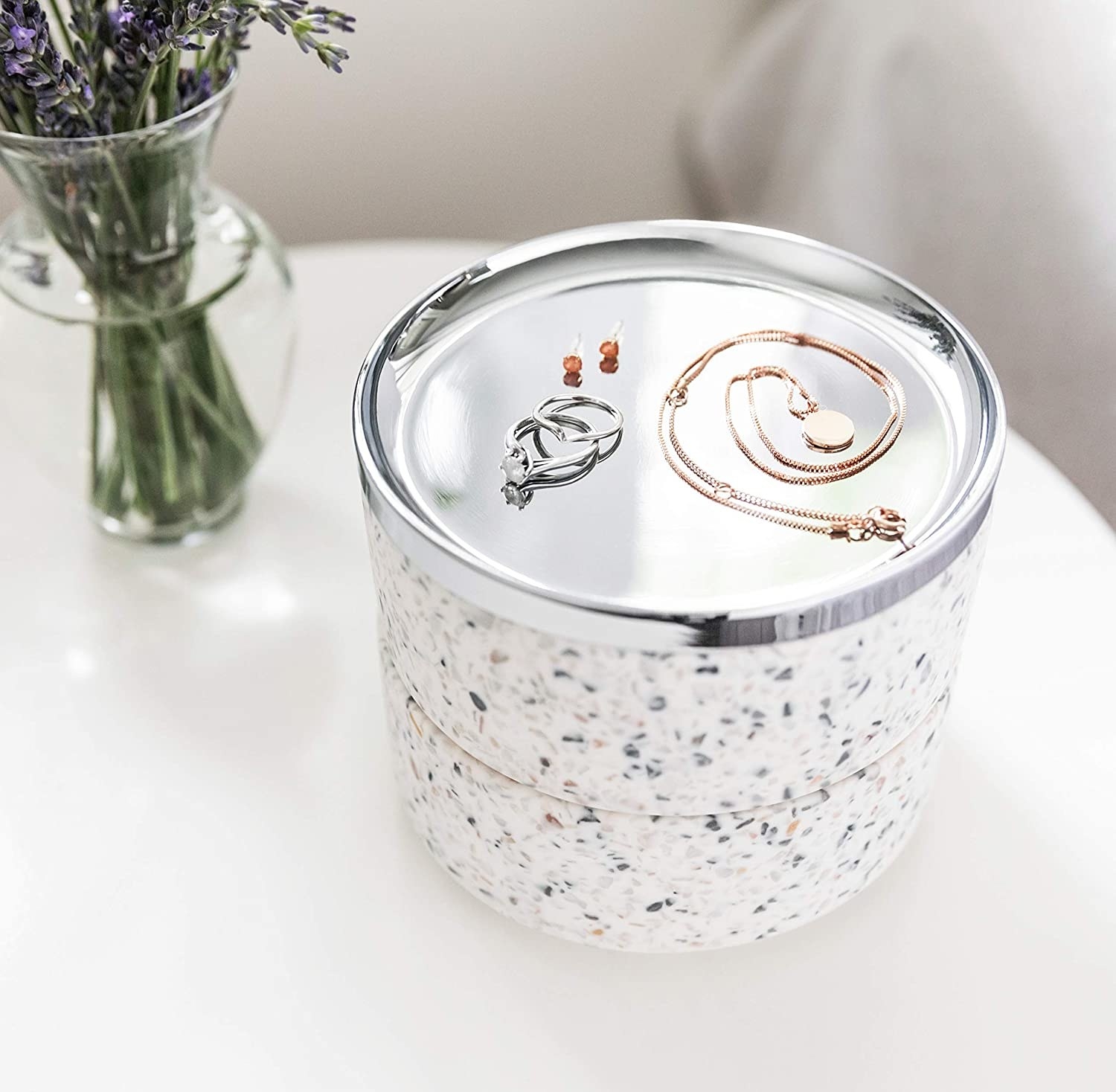 A terrazzo-patterned tiered jewelry box on a counter